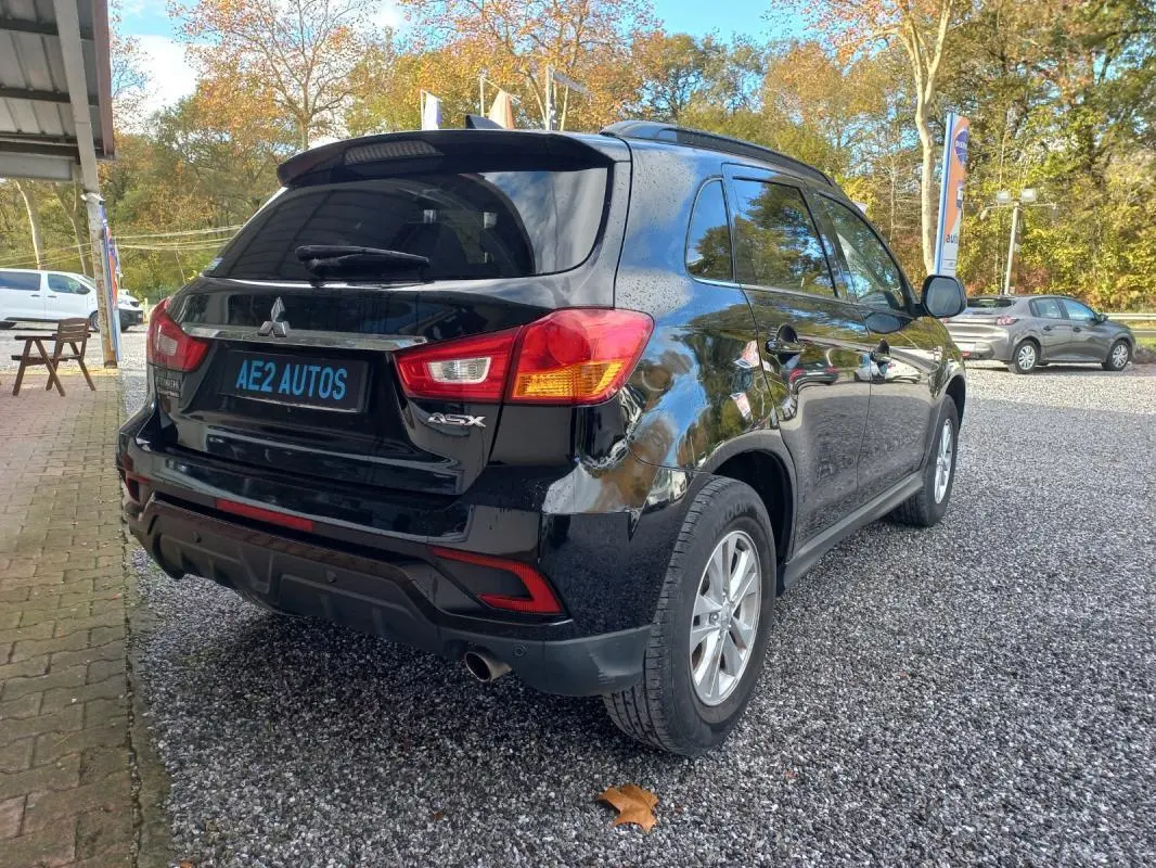Vue 3/4 arrière droite du Mitsubishi ASX Invite 2WD noir 2020 avec jantes 16 pouces sur parking extérieur.