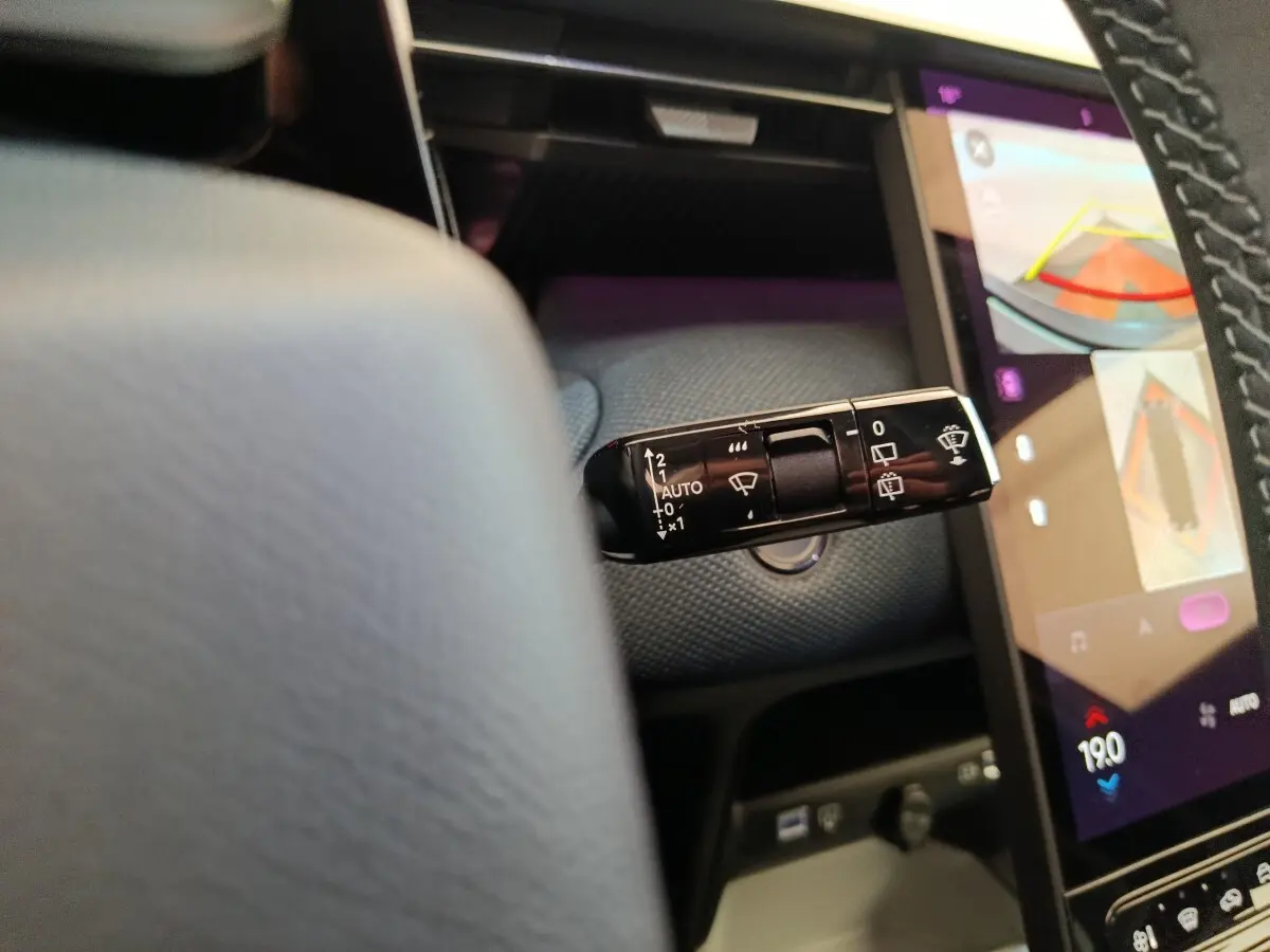 Gros plan sur la commande d’essuie-glace à gauche du volant dans l’habitacle du Citroën C5 hybride gris foncé.