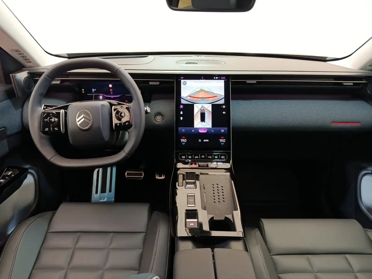 Vue intérieure frontale du tableau de bord et volant cuir noir du Citroën C5 Hybride 2026 avec écran tactile central vertical.