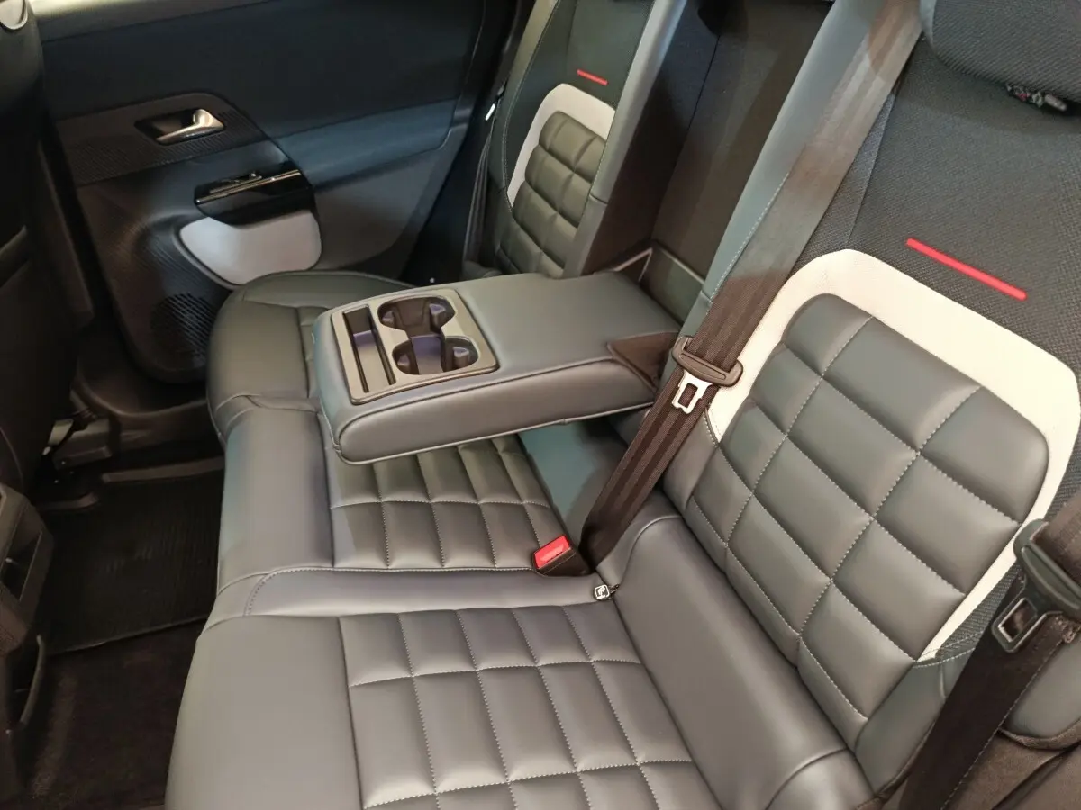 Vue intérieure côté droit des sièges arrière gris foncé avec accoudoir central et porte-gobelets du Citroën C5 Hybride 2026.