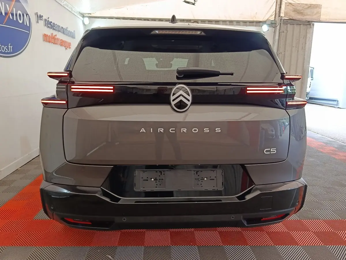 Vue arrière d'un Citroën C5 Aircross gris foncé avec feux LED horizontaux et logo centré sur hayon noir.