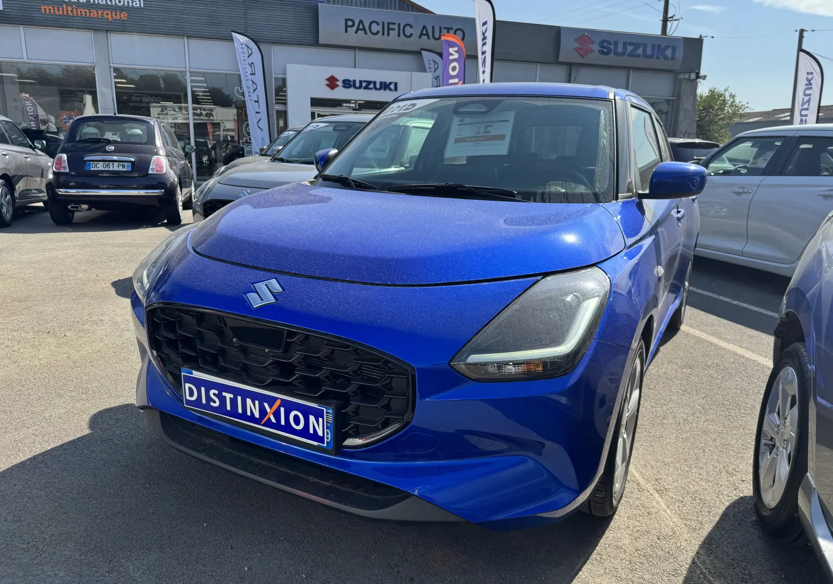 Suzuki Swift 1.2 Privilège Hybrid bleu vue 3/4 avant droit, calandre noire et phares LED, en concession.