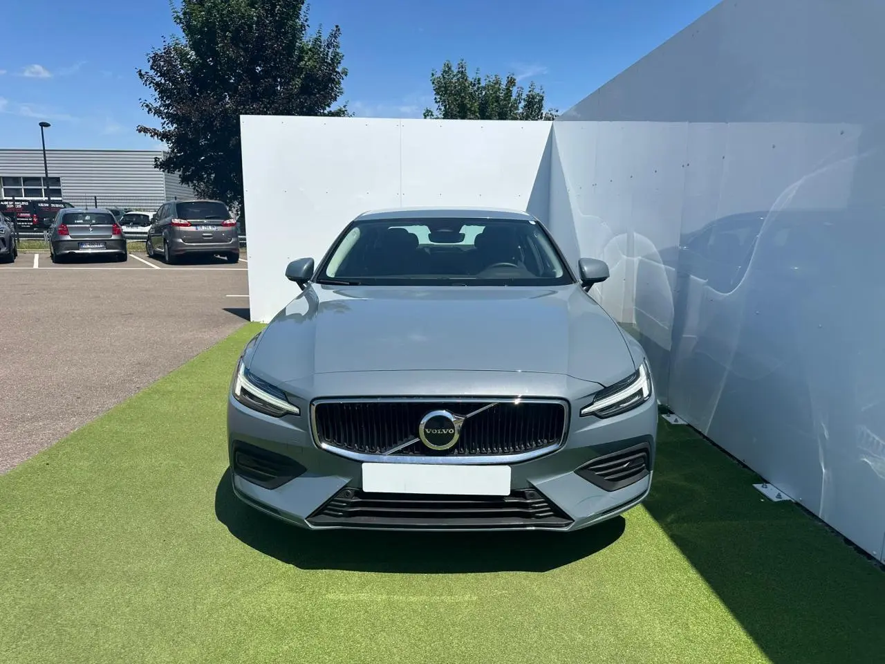 Vue avant d'une Volvo S60 2024 gris Thunder avec calandre chromée et phares LED en forme de marteau de Thor.