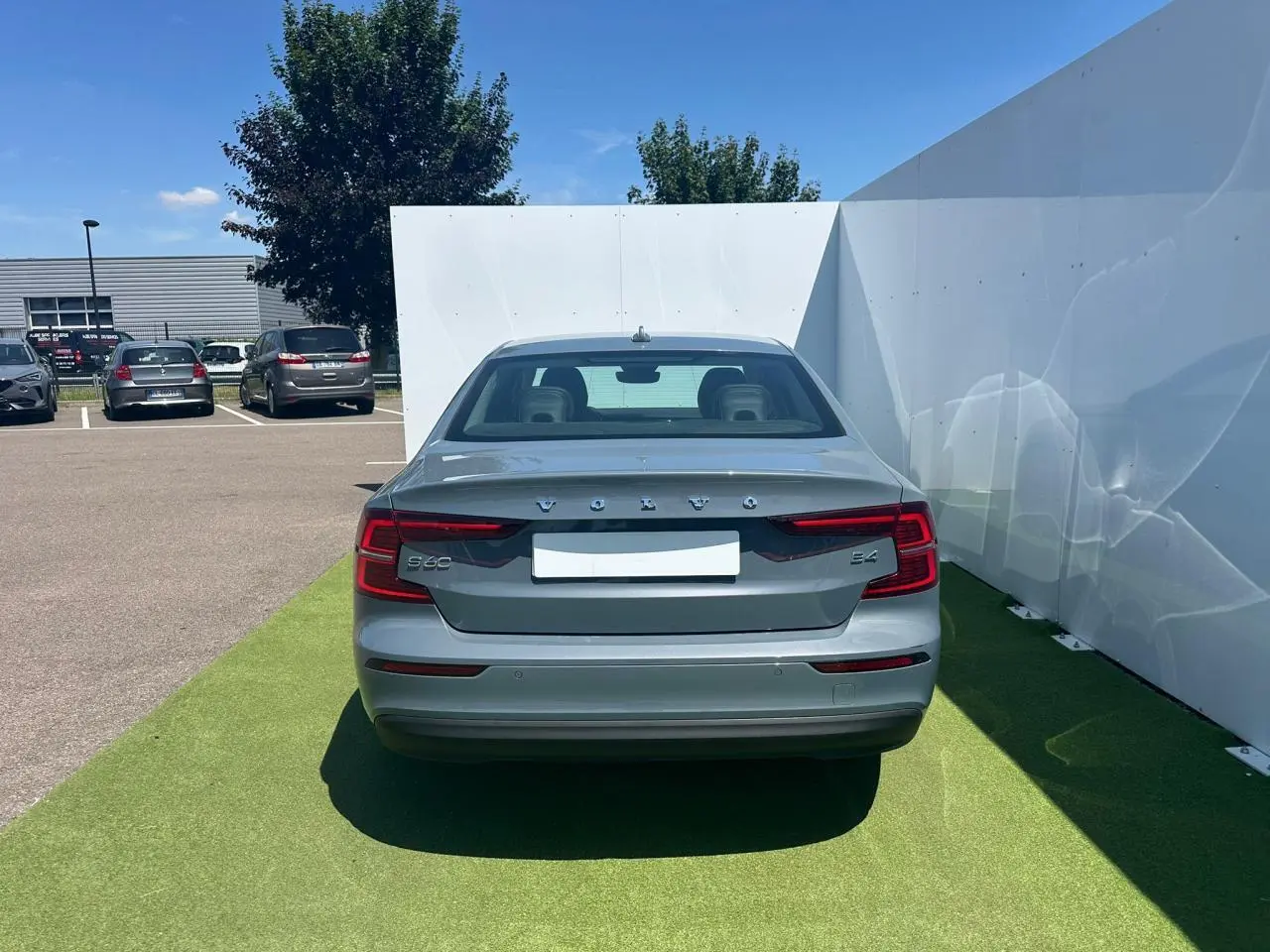 Vue arrière d'une Volvo S60 2024 gris Thunder Grey métallisé avec feux arrière LED et logo distinctif VOLVO.