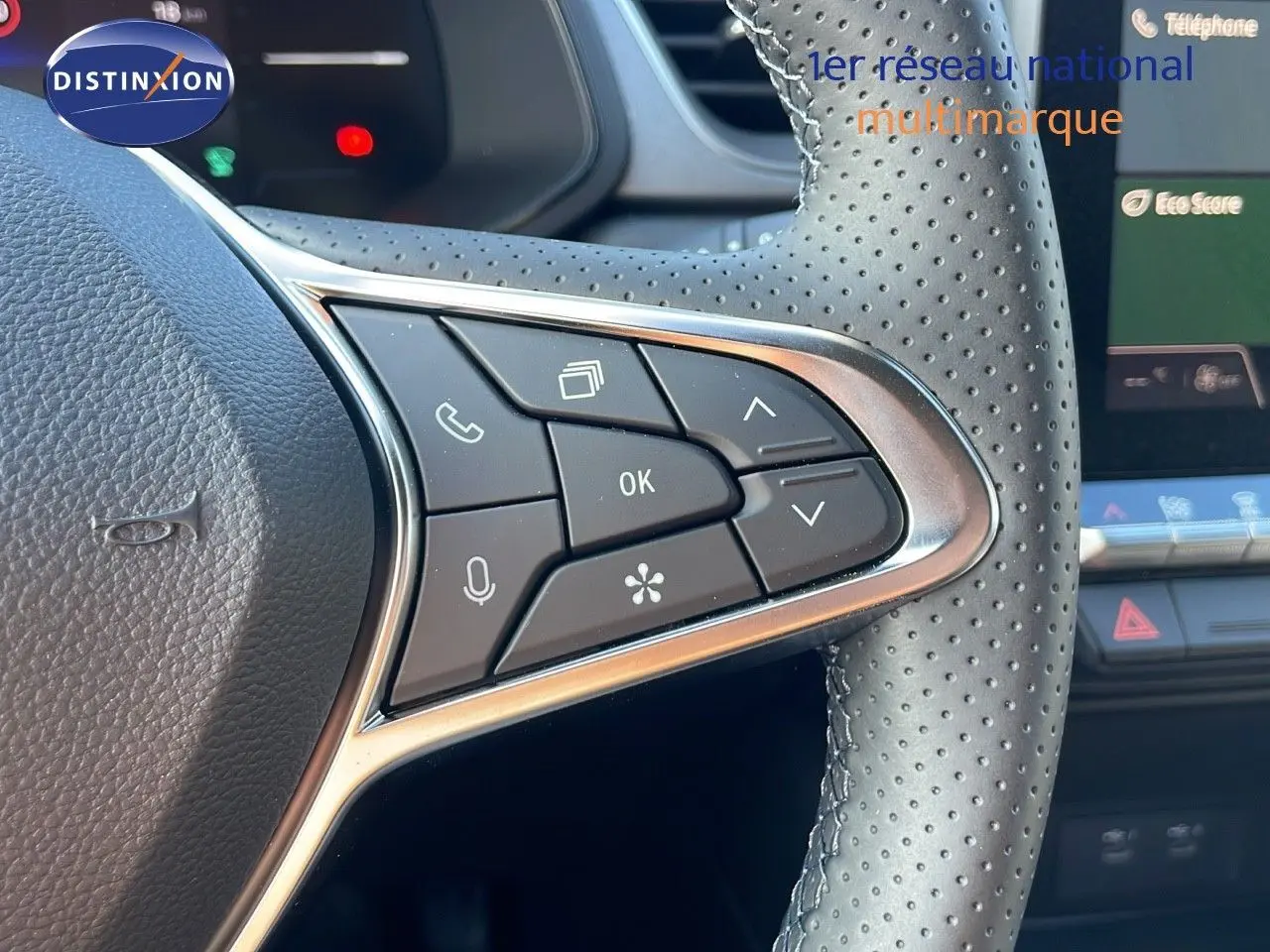 Gros plan sur les commandes multifonctions du volant en cuir perforé du Renault Captur blanc nacré toit gris 2025.