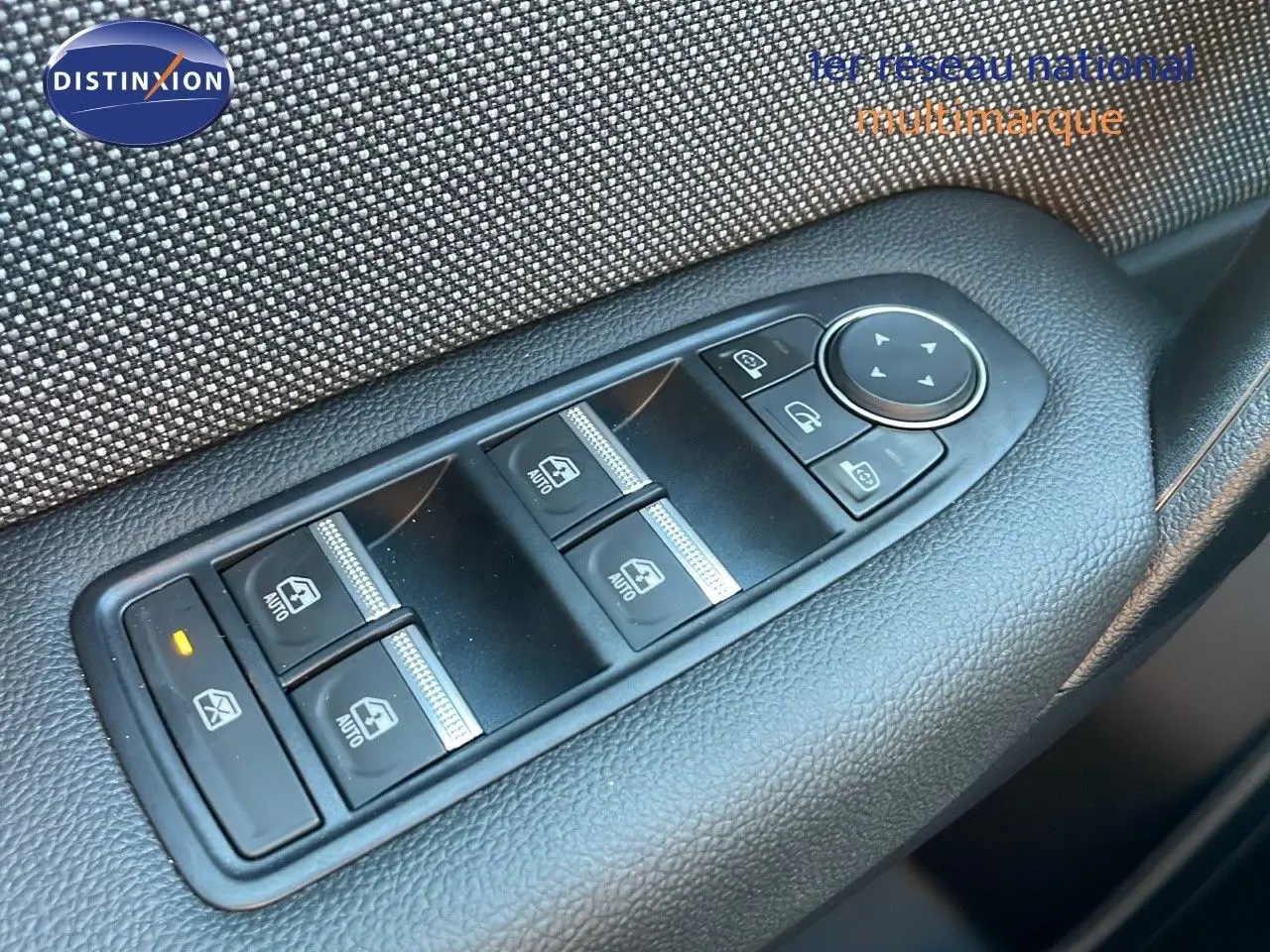 Gros plan sur les commandes des vitres électriques et rétroviseurs côté gauche d'un Renault Captur blanc nacré toit gris.