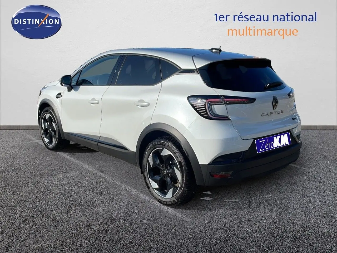 Vue 3/4 arrière droite du Renault Captur blanc nacré avec toit gris, mettant en valeur ses feux LED et jantes biton.