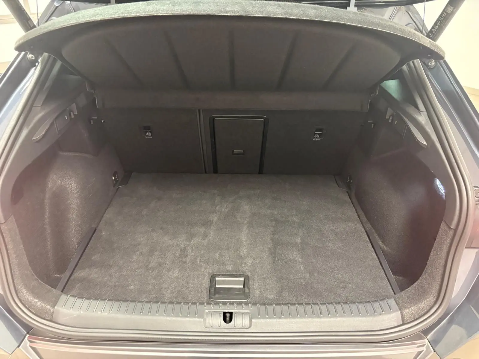 Coffre ouvert vu de l'arrière d'une CUPRA Formentor gris magnétique, montrant l'espace de chargement et la banquette rabattable.