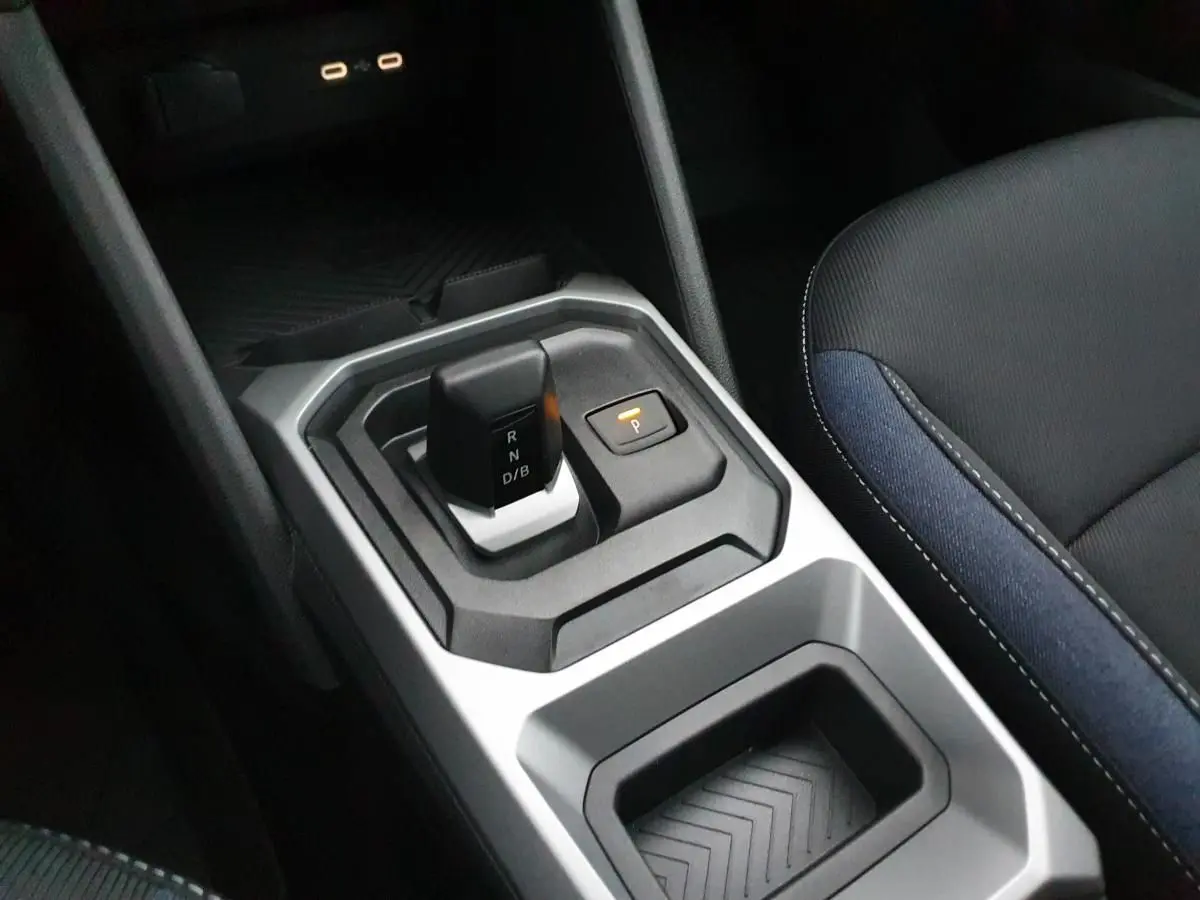 Vue rapprochée de la console centrale du Dacia Duster blanc glacier, avec levier de boîte auto et prises USB type C.