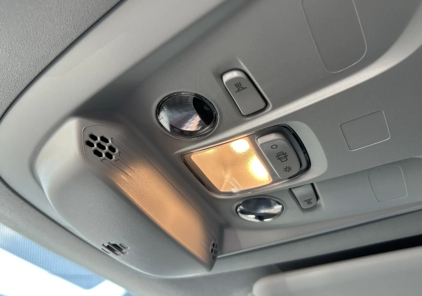 Plafonnier intérieur allumé avec commandes de lumière et micro dans un Peugeot Partner Dangel gris Artense.