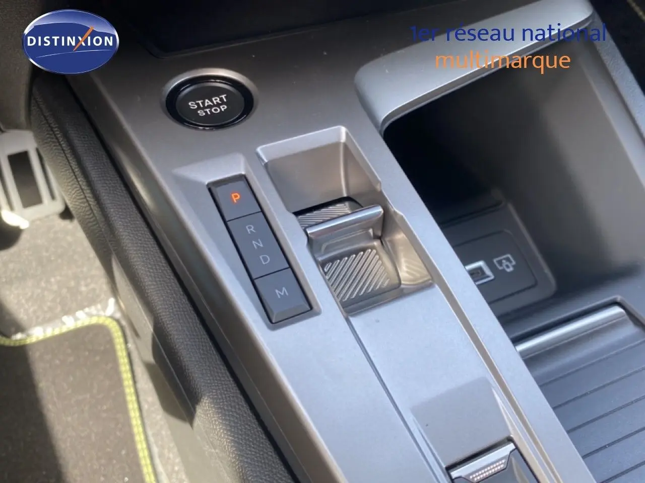 Gros plan sur la console centrale de la Peugeot 308 Hybrid 145ch, montrant le bouton start/stop et la commande de boîte automatique.