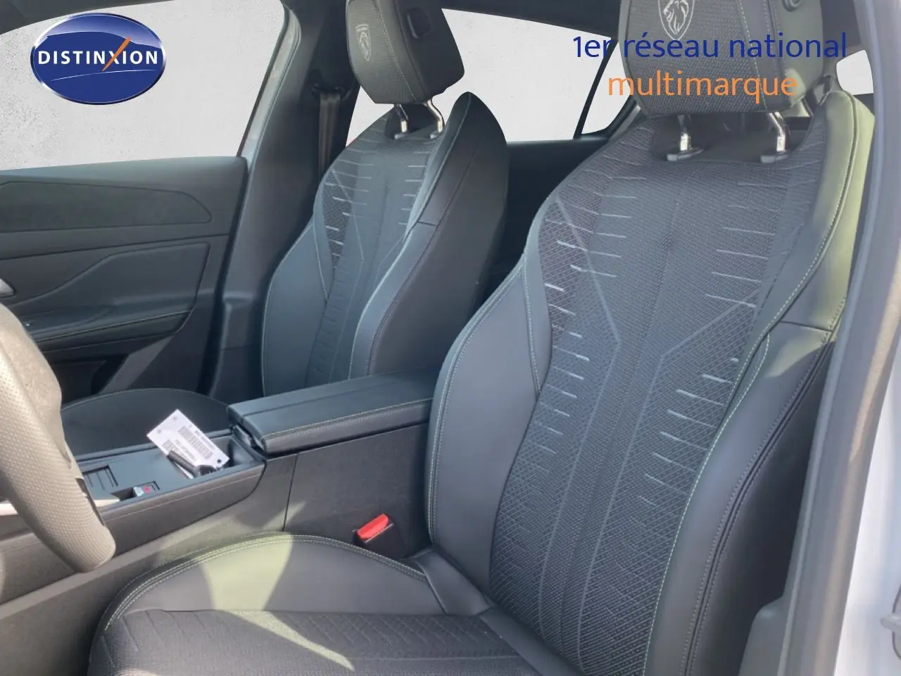 Vue intérieure côté droit des sièges avant en tissu et cuir noir avec logo Peugeot brodé sur les appuie-têtes.