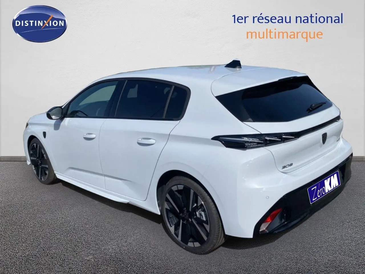 Vue 3/4 arrière droite d'une Peugeot 308 Hybrid 145ch GT blanche Okenite avec jantes noires et vitres teintées.