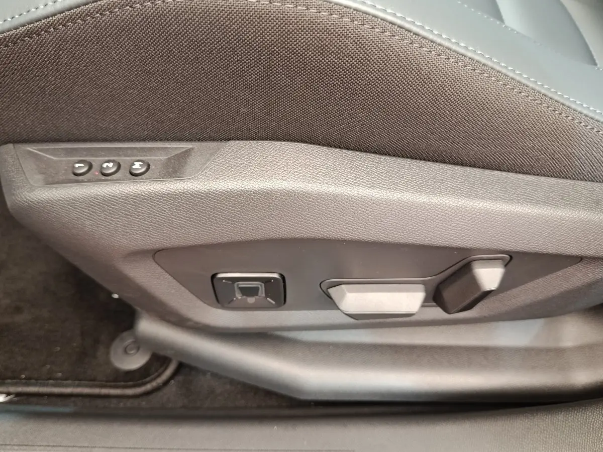 Gros plan sur les commandes de réglage électrique du siège avant gris foncé d'une Citroën C5 hybride 2026.