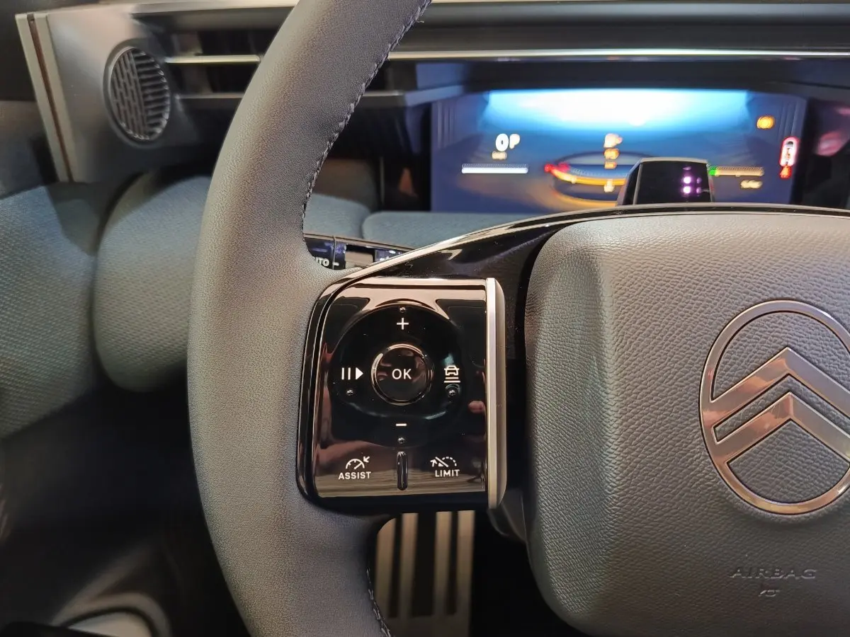 Gros plan sur le volant cuir gris du Citroën C5 Hybride 2026 avec commandes multifonctions et tableau de bord numérique.