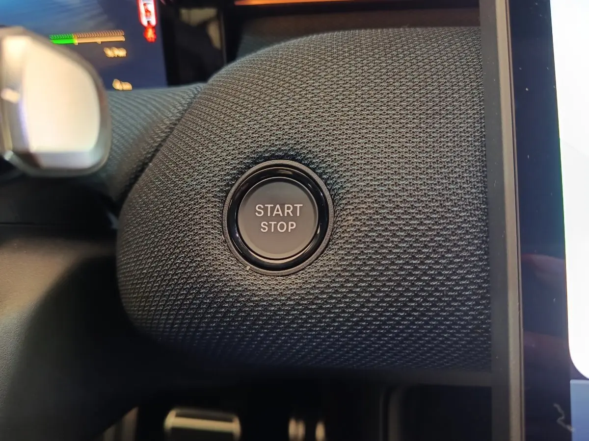 Gros plan sur le bouton start/stop noir intégré dans le tableau de bord texturé du Citroën C5 Hybride 2026.