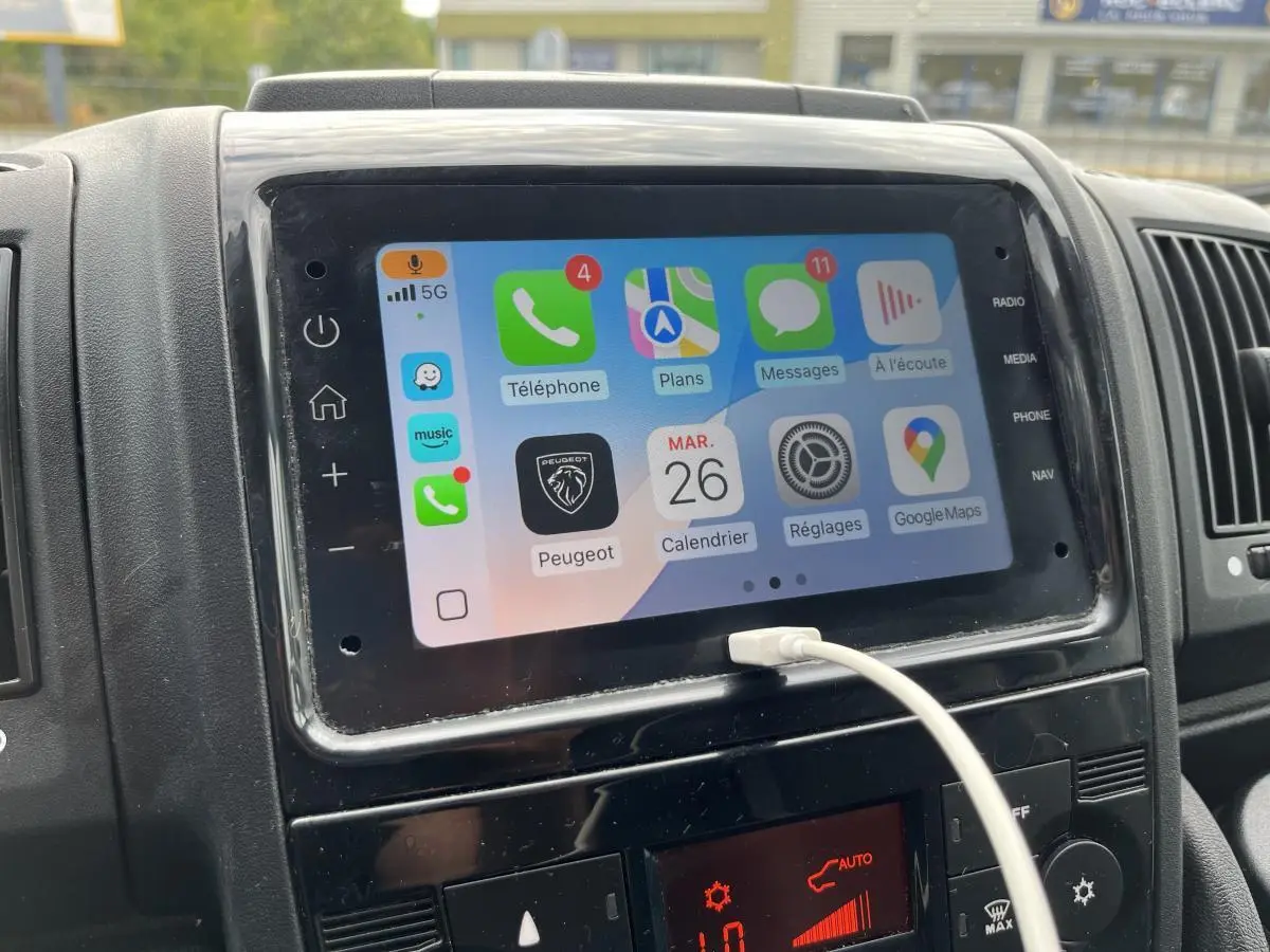 Écran tactile multimédia 7 pouces du Peugeot Boxer Fourgon blanc, avec Apple CarPlay et câble USB connecté.
