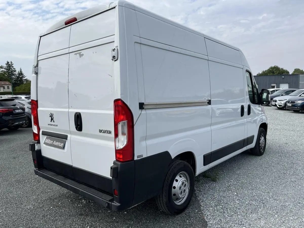 Vue 3/4 arrière droite du Peugeot Boxer Fourgon blanc avec portes arrière tôlées et porte latérale coulissante.