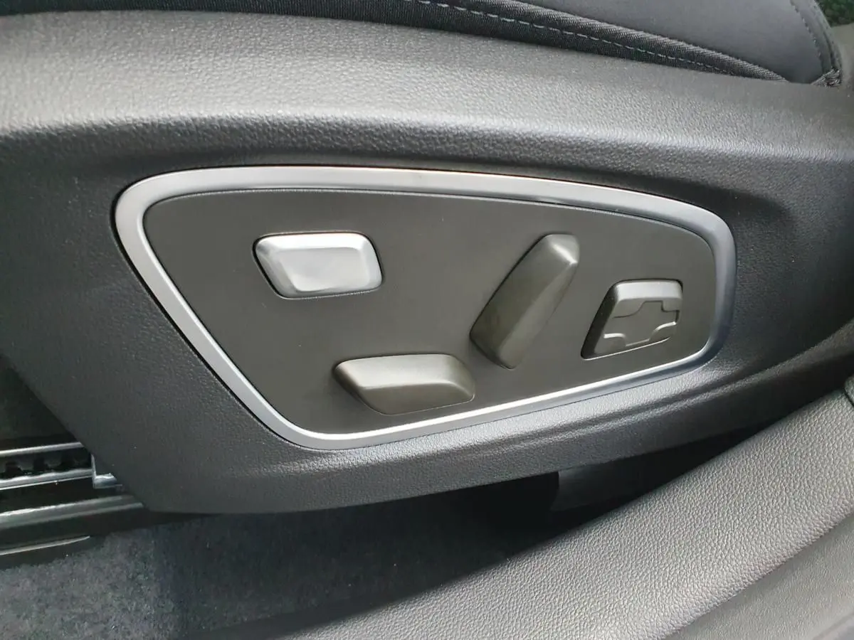 Gros plan sur les commandes électriques de réglage du siège conducteur du Renault Austral gris schiste.