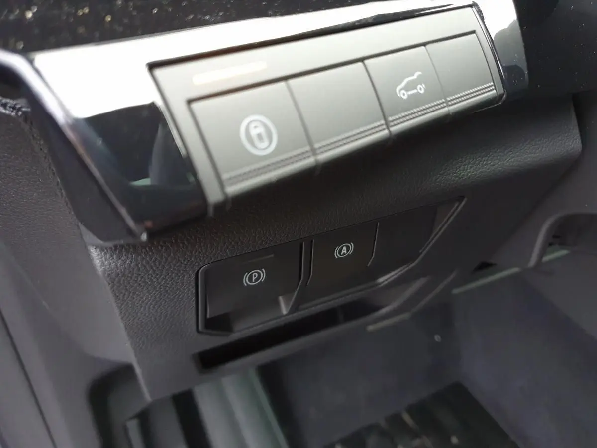 Détail des commandes de frein de parking électrique et assistance au démarrage dans un Renault Austral 2025.