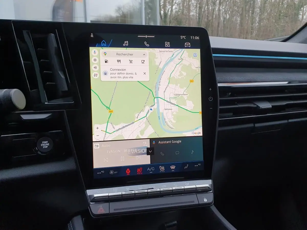 Vue intérieure centrée sur l’écran tactile vertical du tableau de bord du Renault Austral gris schiste avec toit noir.