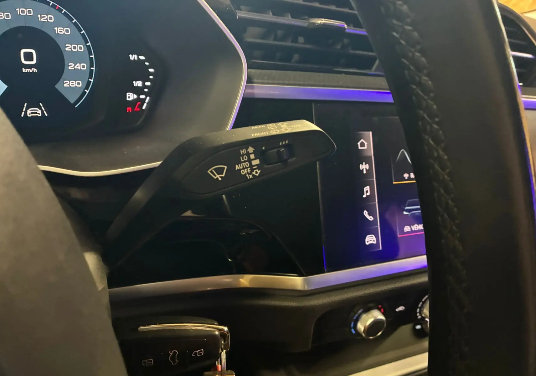 Gros plan intérieur sur le volant et le commodo d’essuie-glace de l’Audi Q3 Sportback 2021 avec tableau de bord numérique.