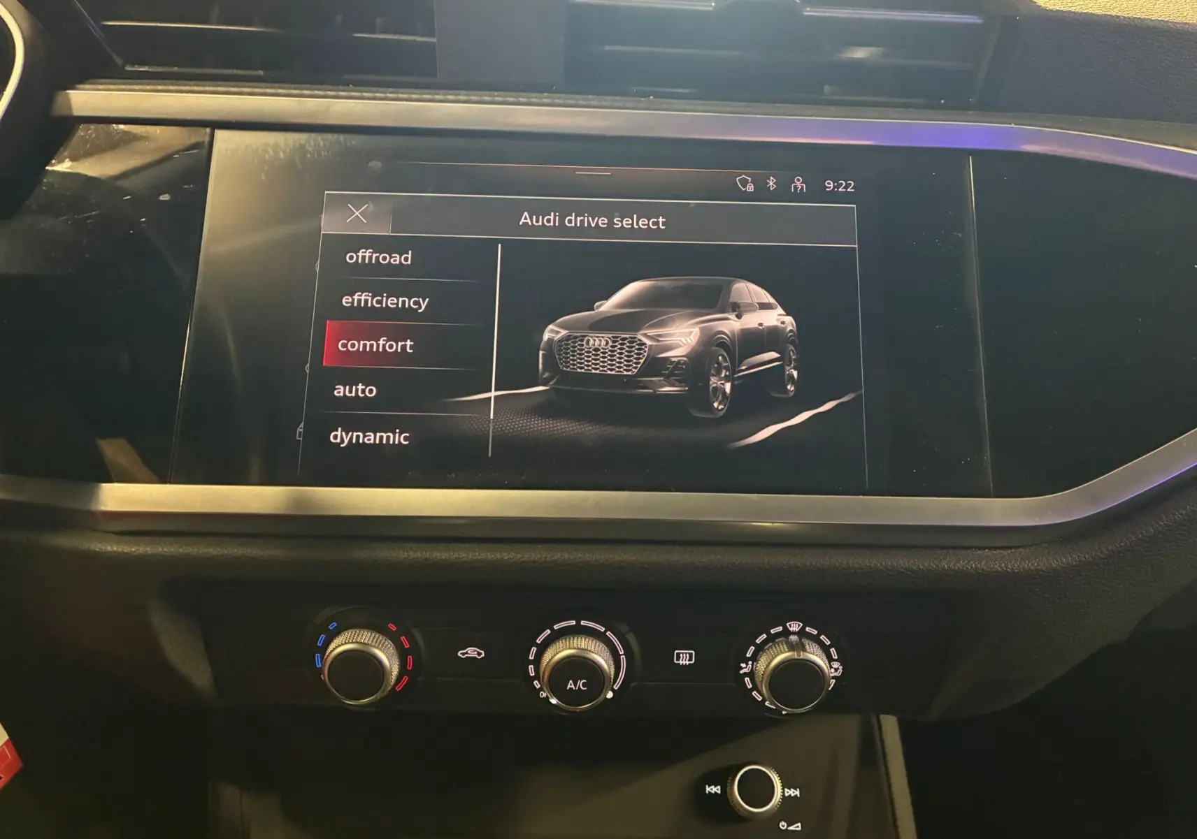 Écran central montrant le mode Audi Drive Select avec une illustration du Q3 Sportback gris en vue 3/4 avant.