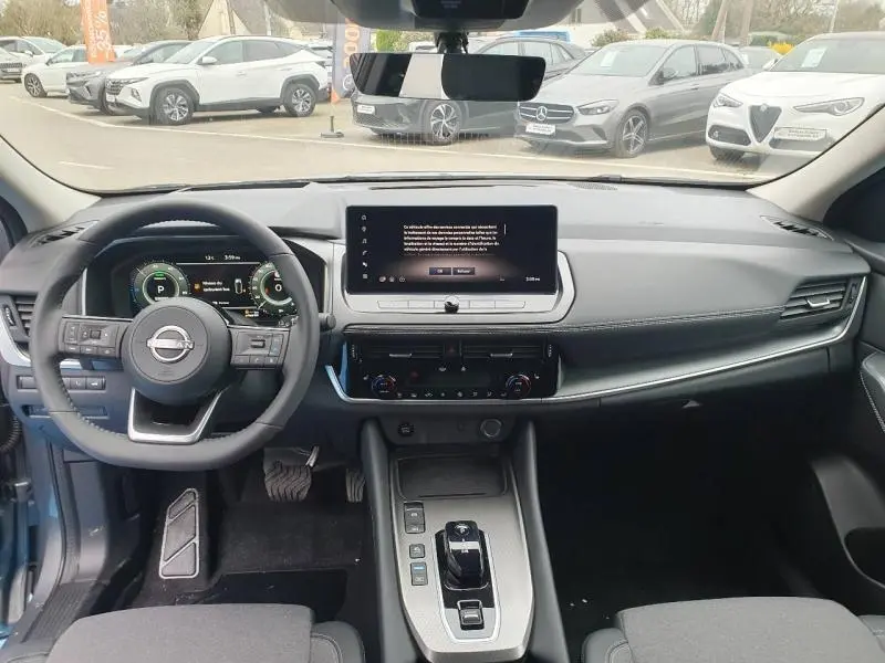 Vue intérieure avant du tableau de bord et volant cuir noir du Nissan Qashqai Hybrid e-POWER 2026 avec écran tactile central.