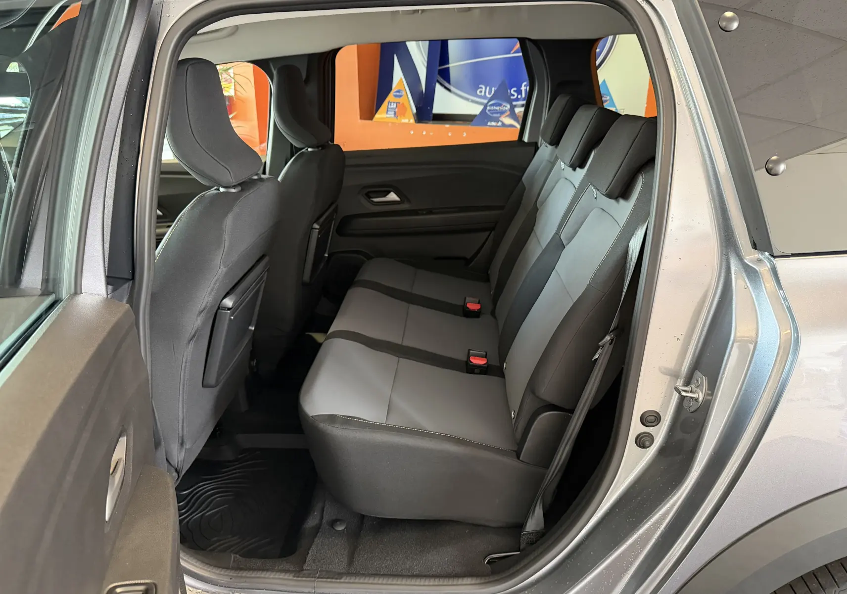 Vue intérieure côté droit sur les sièges arrière en tissu noir et gris du Dacia Jogger gris schiste métal 2026.