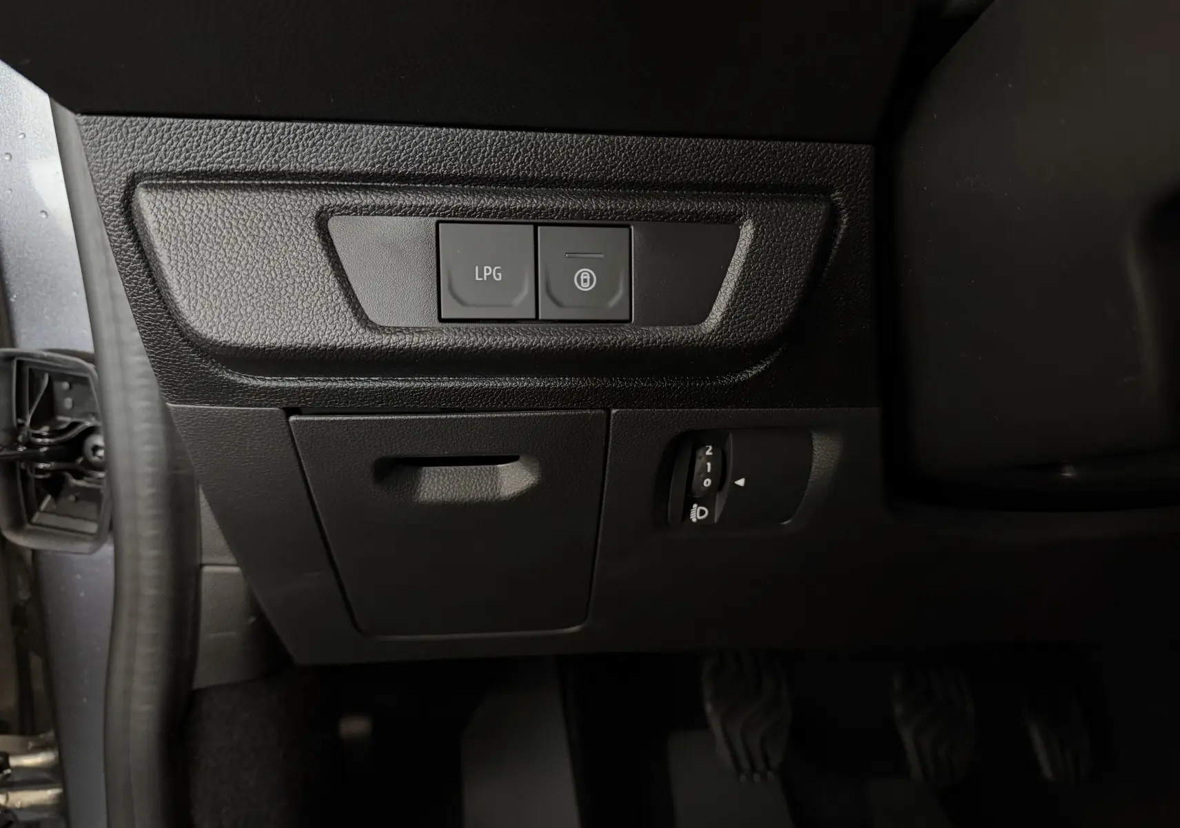 Vue rapprochée du tableau de bord côté gauche avec boutons LPG et verrouillage sur Dacia Jogger gris schiste métal.