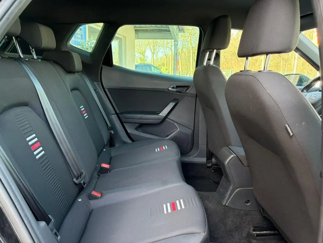 Vue intérieure côté gauche montrant la banquette arrière noire avec motifs gris et rouge du SEAT Arona 2020.