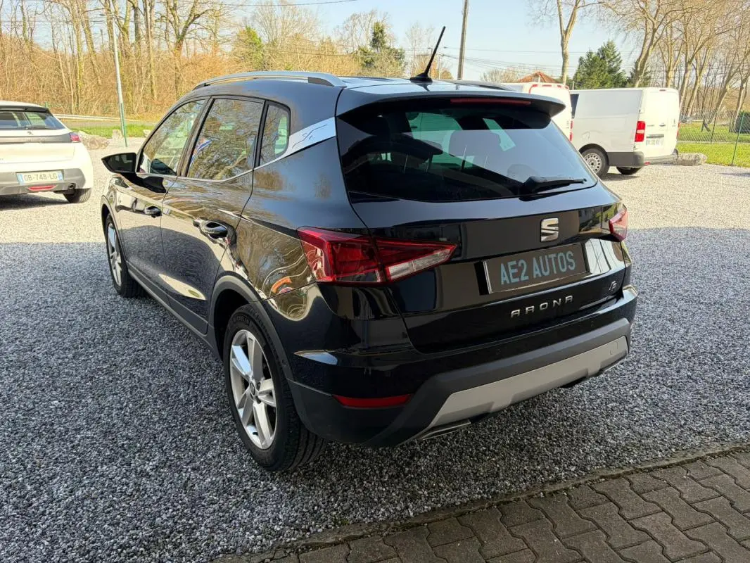 Vue 3/4 arrière droite d'un SEAT Arona noir 2020 avec jantes alliage et badge FR visible sur le montant arrière.