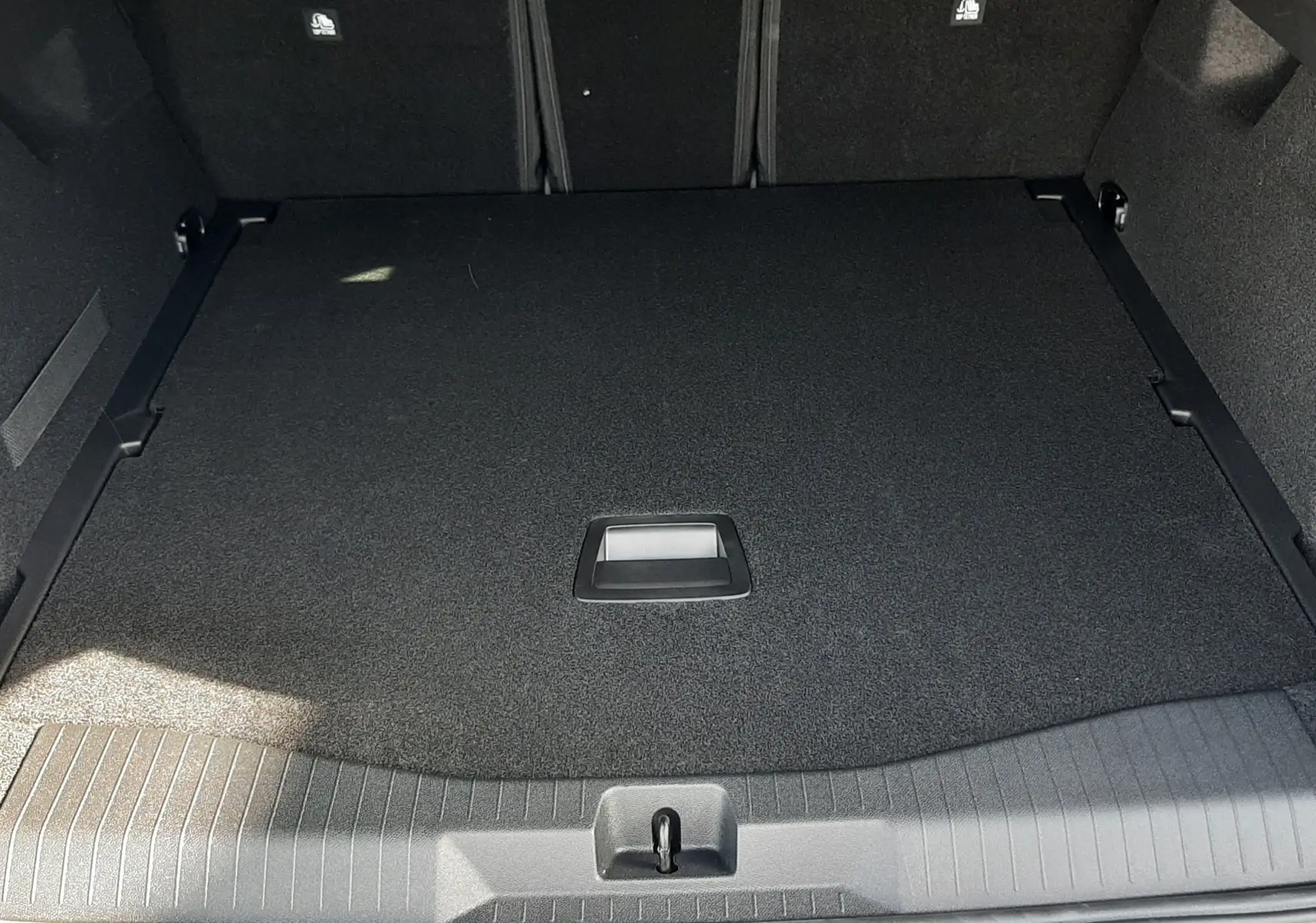 Coffre ouvert vu de l'arrière du Citroën C5 Aircross vert Astoria avec intérieur noir et plancher plat.