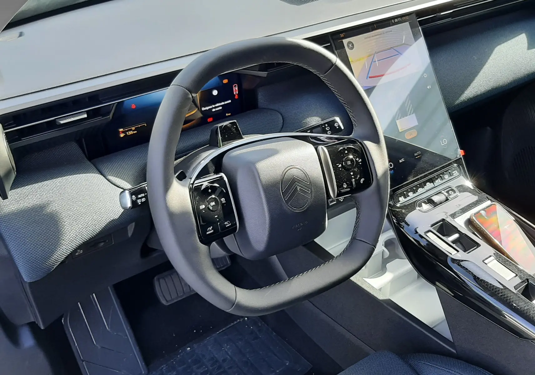 Vue intérieure du poste de conduite du Citroën C5 Aircross hybride 2026, avec volant multifonction et écran tactile vertical.