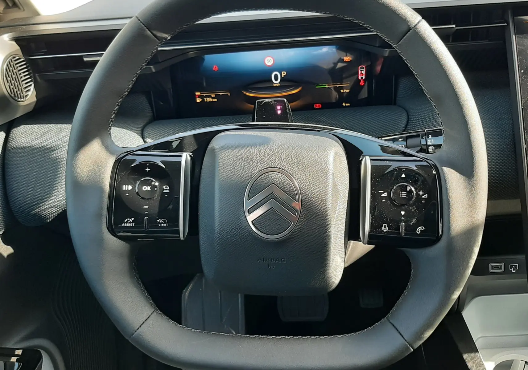 Vue rapprochée du volant noir du Citroën C5 Aircross 2026 avec commandes tactiles et tableau de bord numérique.