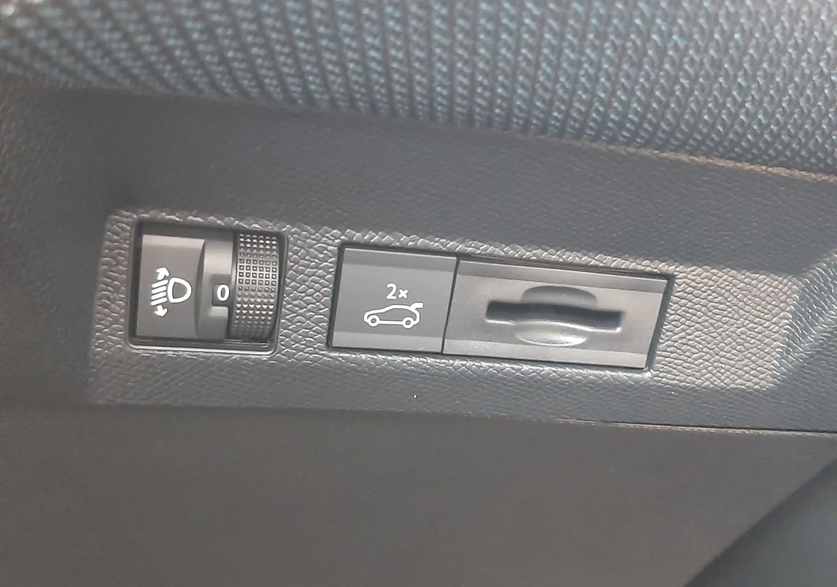 Gros plan sur les commandes intérieures du hayon électrique et réglage des phares du Citroën C5 Aircross hybride.