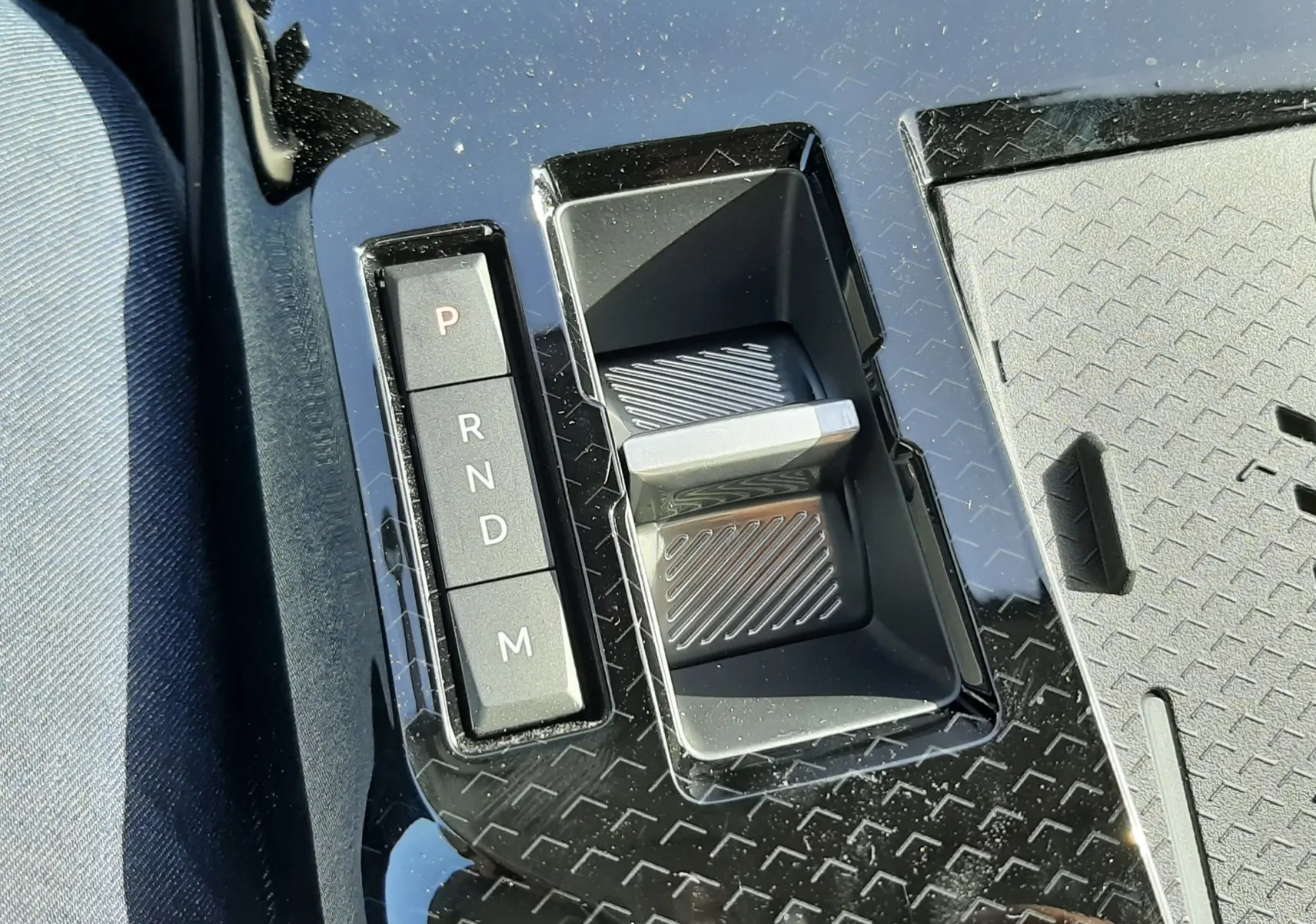 Gros plan sur la console centrale du Citroën C5 Aircross hybride 2026, avec levier de vitesses automatique et boutons de sélection P, R, N, D, M.