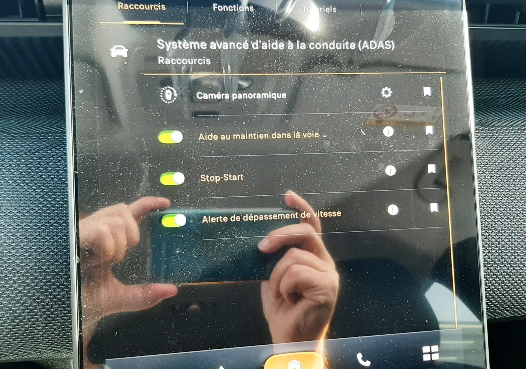 Écran tactile intérieur du Citroën C5 Aircross 2026 montrant les options d’aide à la conduite, reflet de mains visible.