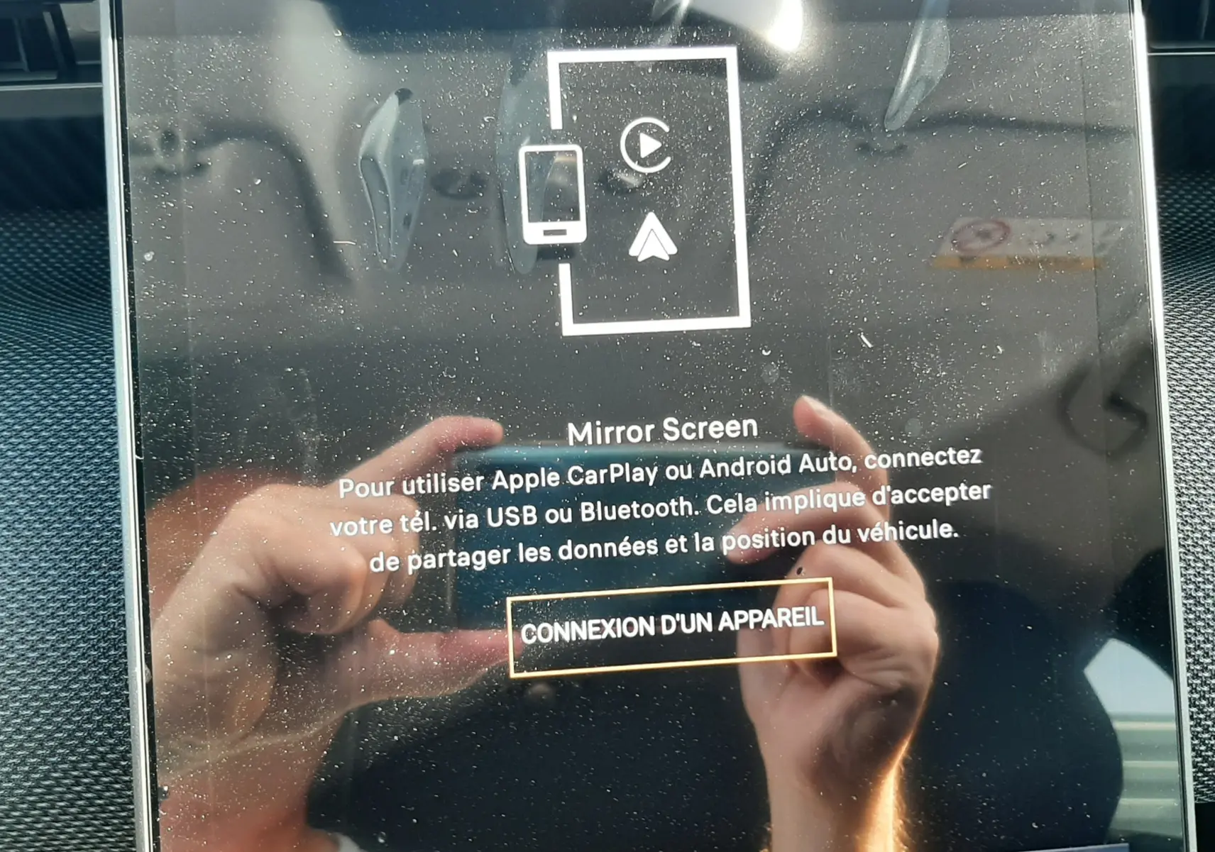 Écran tactile central du Citroën C5 Aircross 2026 affichant la connexion Mirror Screen, avec reflet des mains.