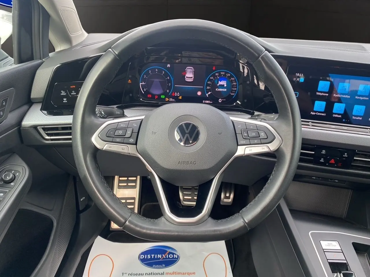 Vue intérieure centrée sur le volant et tableau de bord numérique de la Volkswagen Golf VIII noire de 2022.