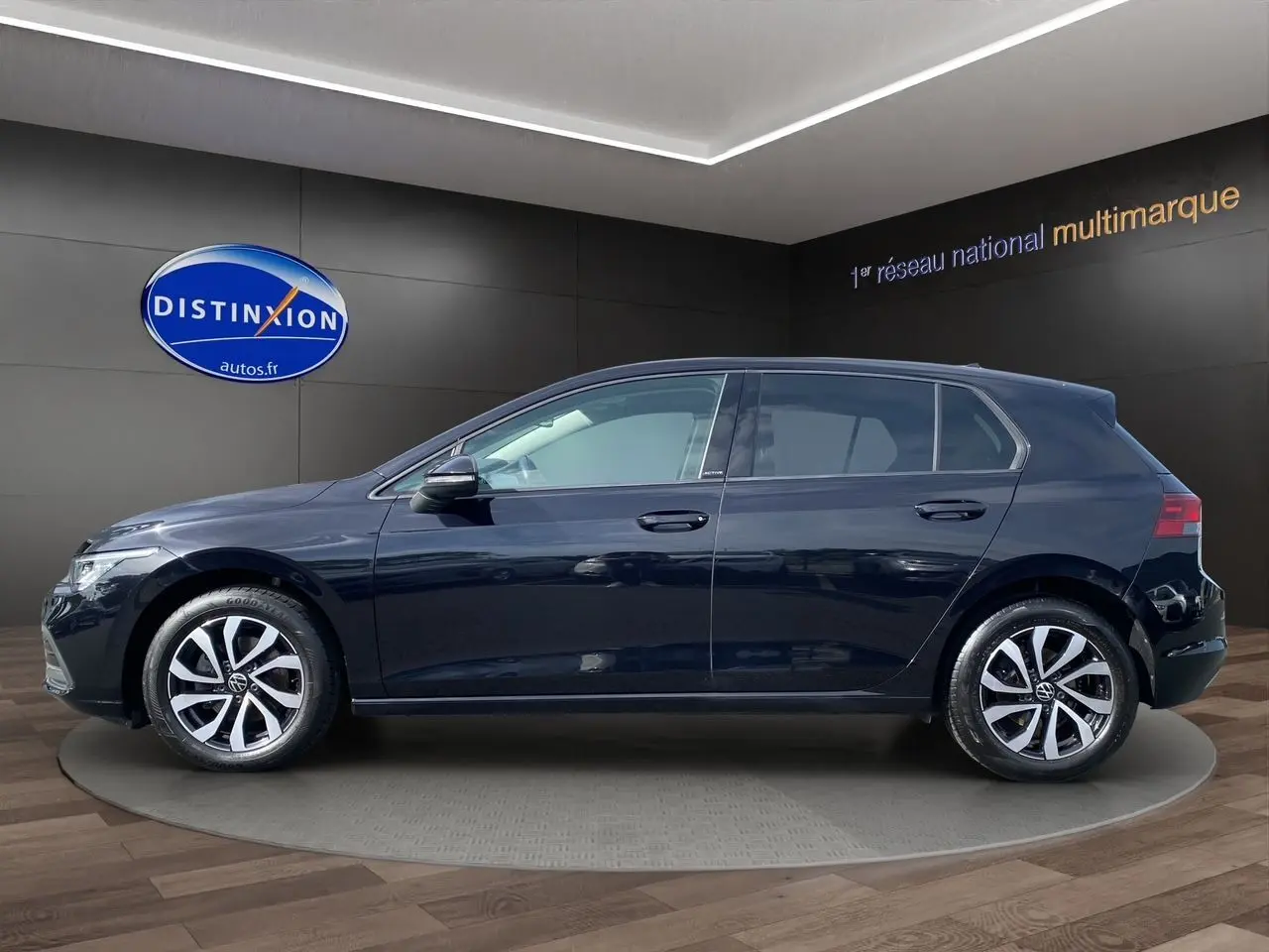 Profil côté gauche d'une Volkswagen Golf VIII noire avec vitres surteintées, jantes alliage et caméra de recul visible.