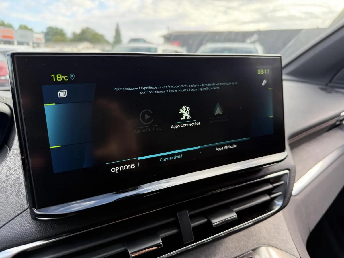 Écran tactile central du Peugeot 3008 Hybrid 2023 affichant les options de connectivité dans un intérieur gris.