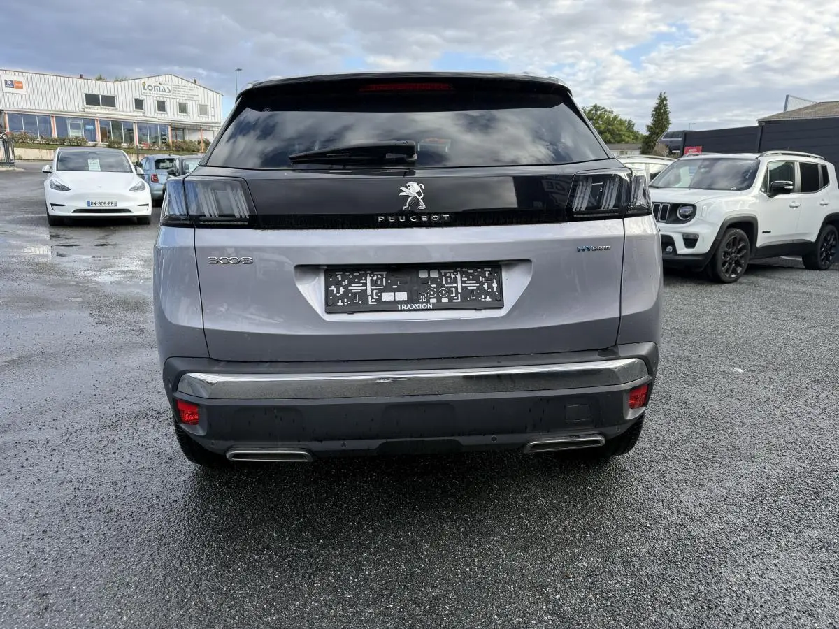 Vue arrière d'un Peugeot 3008 Hybrid gris métallisé avec feux arrière LED 3D et double sortie d'échappement chromée.