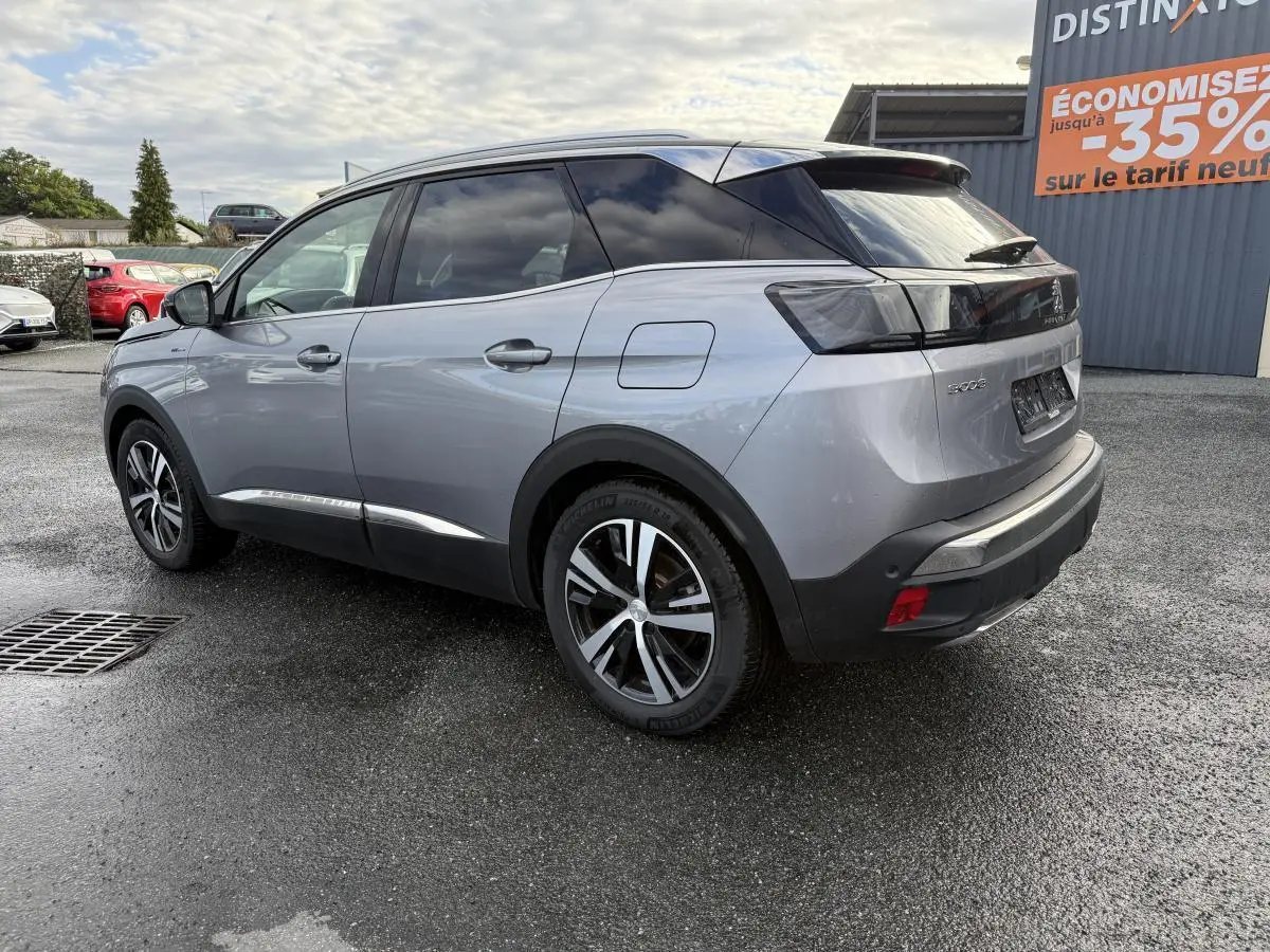 Vue 3/4 arrière droite du Peugeot 3008 Hybrid gris métallisé avec toit noir et jantes bi-ton diamantées.