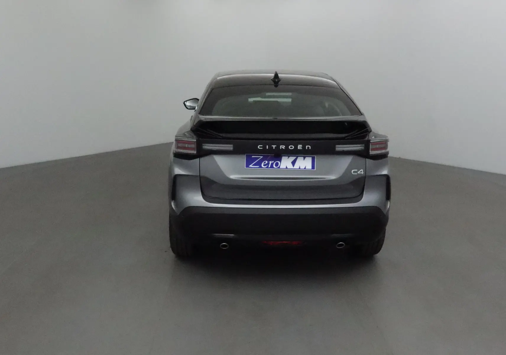 Vue arrière d'une Citroën C4 1.2 Hybrid 136 Business Edition gris Mercury et noir avec feux LED et double sortie d'échappement.