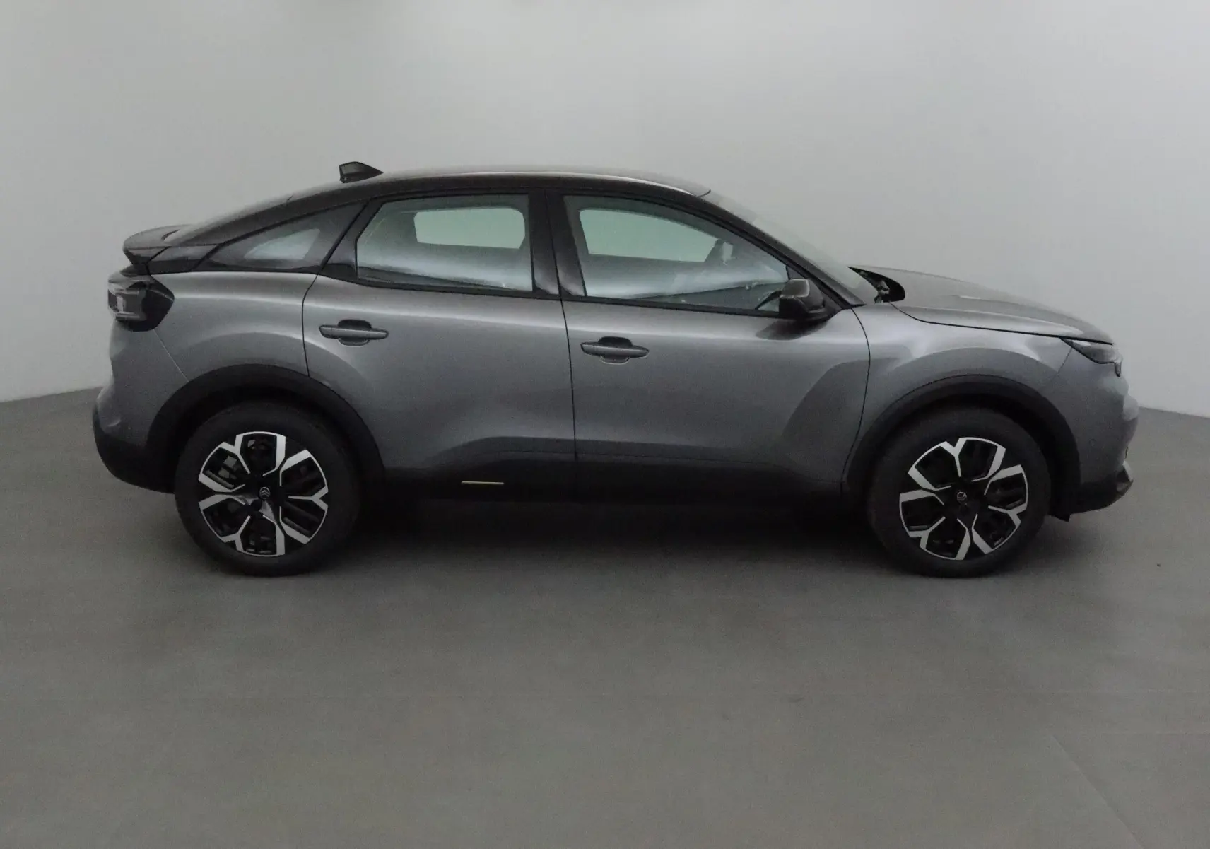Profil côté gauche d'une Citroën C4 1.2 Hybrid 136 Business Edition gris mercury et noir, jantes 18 pouces.