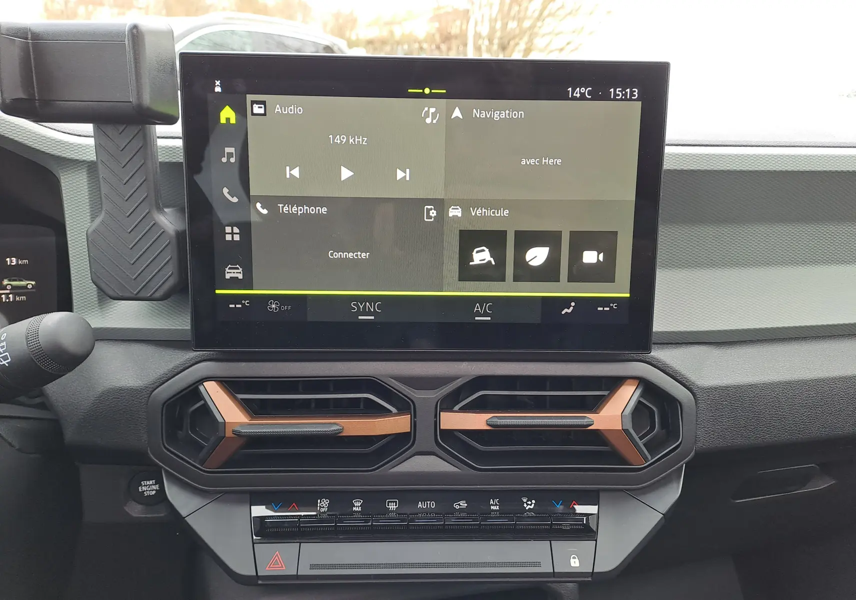 Vue intérieure centrée sur l’écran tactile et les aérateurs noirs avec inserts cuivre du tableau de bord du Dacia Bigster 2025.