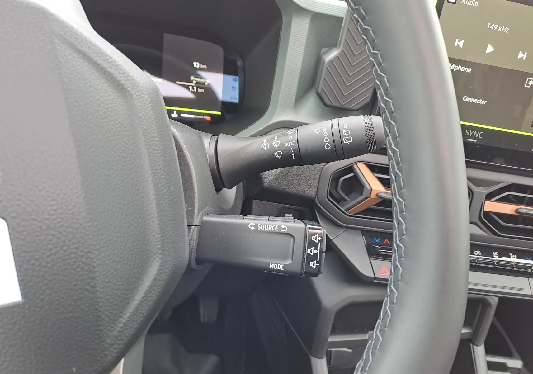 Vue rapprochée du volant et des commandes au volant du Dacia Bigster noir nacré, avec tableau de bord digital et aérateurs hexagonaux.