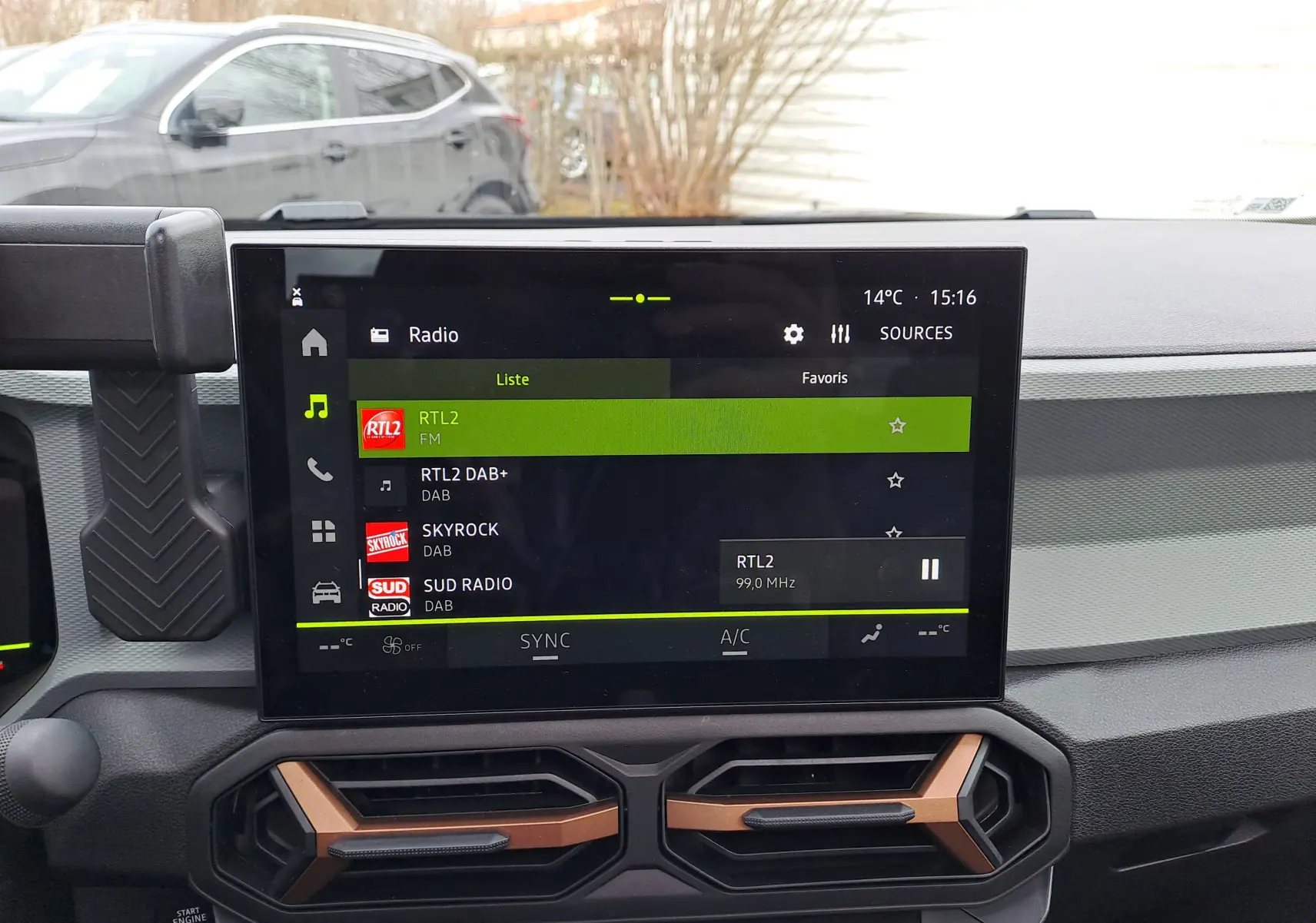 Vue intérieure centrée sur l’écran tactile multimédia du Dacia Bigster noir nacré, avec commandes de climatisation visibles.