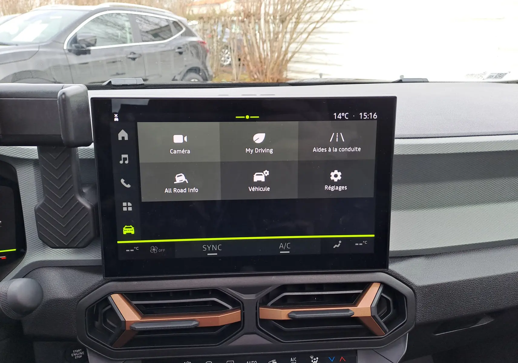 Vue intérieure centrée sur l’écran tactile du tableau de bord du Dacia Bigster noir nacré, avec aérateurs bronze visibles.